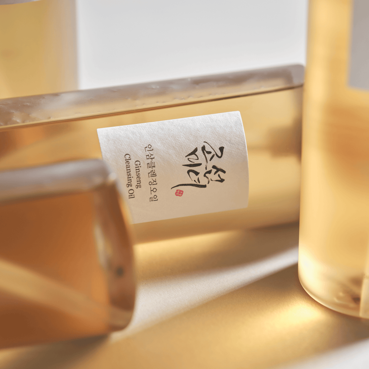 Detalle de la etiqueta de Beauty of Joseon Ginseng Cleansing Oil en frascos tumbados
